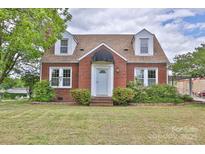 Charming two-story brick home featuring dormer windows, a covered entryway, and well-maintained landscaping at 2036 1St Sw Ave, Hickory, NC 28602