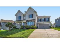 Charming two-story home featuring stone accents, gray siding, and a well-manicured lawn with a concrete driveway at 2322 Tessa Trce, Clover, SC 29710