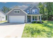 Charming two-story home featuring a well-maintained lawn, attached garage, and inviting front porch at 2902 Oakdale Rd, Charlotte, NC 28216