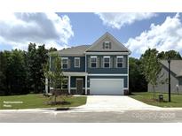 Inviting two-story home boasts a well-manicured lawn and a charming facade with a two-car garage at 6443 Honor Ave, Midland, NC 28107