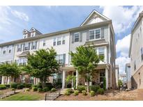 Charming two-story townhome featuring stone accents, covered porch, and landscaped front yard under a bright blue sky at 9521 Ainslie Downs St, Charlotte, NC 28273