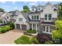 Charming two-story home with a combination of stone and white siding, dormer windows, and a two-car garage at 1012 N Sharon Amity Rd, Charlotte, NC 28211