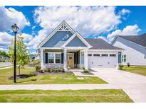 Charming single-Gathering home boasts a manicured lawn, attached two-car garage, and inviting front porch at 105 Chase View Ln, Troutman, NC 28166