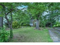 Charming brick home with lush greenery and mature trees creating a serene and private setting at 109 N Belvedere Ave, Gastonia, NC 28054