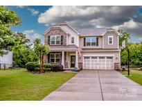 Charming two-story home boasts stone accents, a well-manicured lawn, and a spacious two-car garage at 130 Bay Laurel Dr, Mooresville, NC 28115