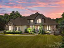 Charming exterior elevation featuring stone accents, manicured landscaping, and a well-maintained lawn at 14010 Mccord Rd, Huntersville, NC 28078