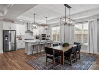 Bright, open kitchen features white cabinets, stainless steel appliances, and an island with barstool seating at 1634 Dresden Dr, Rock Hill, SC 29732
