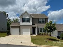 Two-story home with attached two-car garage, well-maintained lawn and beautiful landscaping at 165 Clove Hitch Dr # I281, Statesville, NC 28677
