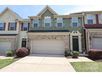Charming townhome featuring a neutral garage door, brick accents, and manicured landscaping in a desirable community at 1809 Evergreen Dr, Charlotte, NC 28208