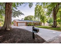 Charming brick home featuring mature trees, a two-car garage, and a long, paved driveway at 195 Brookfield Cir, Mooresville, NC 28115