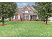 Traditional brick home with a well-manicured lawn and mature landscaping, perfect for curb appeal at 212 Forest Walk Way, Mooresville, NC 28115