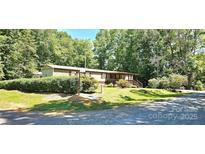 Charming single-story home with a welcoming front porch and mature trees surrounding the property at 217 Eighth Ave, New London, NC 28127