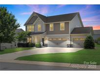Charming two-story home features a three-car garage, manicured lawn, and inviting curb appeal at 3211 Gilroy Dr, Fort Mill, SC 29707