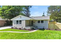 Charming home with a well-manicured lawn, newly planted shrubs, and a painted brick facade at 4042 Uppergate Ln, Charlotte, NC 28215