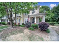 Inviting townhome showcasing charming curb appeal with lush landscaping and an American flag at 413 Hurston Cir, Charlotte, NC 28208