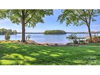 Picturesque waterfront lawn, featuring a sandy beach and dock access to the calm lake at 495 Bay Harbour Rd, Mooresville, NC 28117