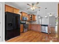 Well-lit kitchen showcasing wood cabinets, stainless steel appliances, and hardwood flooring at 5076 Newport Lakes Dr, Rock Hill, SC 29732