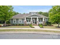 Charming single-story home featuring a welcoming front porch, manicured lawn, and beautiful landscaping at 508 Flour Mill Ct, Fort Mill, SC 29715