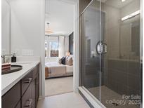 Modern bathroom featuring glass-enclosed shower and bedroom view with natural light at 5517 Swaling St, Charlotte, NC 28217
