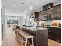 Modern kitchen featuring a spacious island with seating, stainless steel appliances, and open concept design at 5517 Swaling St, Charlotte, NC 28217