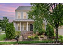 Charming two-story home with manicured landscaping, inviting front porch, and classic architectural details at 6948 Church Wood Ln, Huntersville, NC 28078