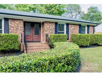 Charming brick home with a manicured front yard and decorative glass front doors at 7416 Quail Ridge Dr, Charlotte, NC 28226