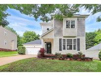 Charming two-story home with manicured lawn, lush landscaping, and a detached garage at 7544 Rolling Meadows Ln, Huntersville, NC 28078