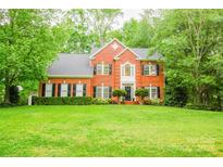 Beautiful two-story brick home with black shutters and mature landscaping at 12314 Chickasaw Dr, Huntersville, NC 28078