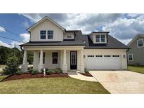 Charming two-story home with a two car garage, a manicured lawn, and beautiful landscaping at 13605 Tranquil Day Dr, Matthews, NC 28105