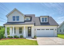 Charming two-story home features a white painted brick facade, attached garage, and well-manicured lawn at 13605 Tranquil Day Dr, Matthews, NC 28105