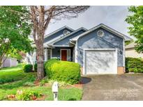 Charming blue house with a well-manicured lawn, attached garage, and inviting curb appeal at 2915 Cherry Blossom Ct, Fort Mill, SC 29715