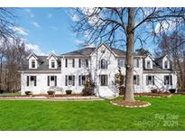 Stunning two-story home with a manicured lawn and classic architectural details at 4001 Carmel Acres Dr, Charlotte, NC 28226