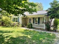 Charming single-story home with a cozy front porch and mature landscaping at 401 Overlook Dr, Monroe, NC 28110