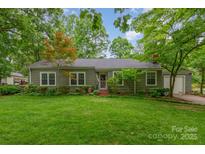 Charming single-story home with green lawn, mature trees, and inviting front porch at 408 Idlewood Dr, Kannapolis, NC 28083