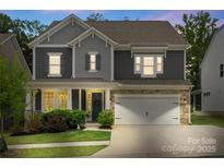Charming two-story home with a stone-accented garage and inviting front porch at dusk at 4174 Charlton Rd, Fort Mill, SC 29715