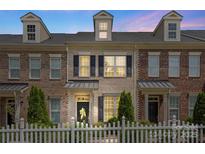 Charming brick townhome with dormers, black shutters, tasteful landscaping and a white picket fence at 4313 Courtly Ln, Belmont, NC 28012