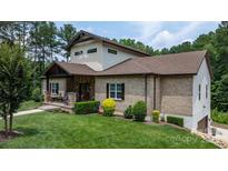Beautiful brick home with well-manicured lawn and inviting front porch with stone and wood accents at 4616 Gold Finch Dr, Denver, NC 28037