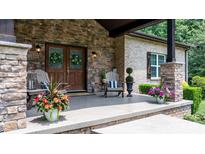 Charming front porch featuring stone pillars, wood doors, and decorative plants, creating a welcoming entrance at 4616 Gold Finch Dr, Denver, NC 28037