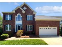 Classic red brick two-story home featuring a two-car garage, dark shutters, and manicured lawn at 903 Furman Ct, Fort Mill, SC 29708