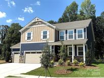 Charming two-story home featuring a three-car garage and manicured front yard at 9945 Cask Way, Huntersville, NC 28078