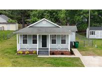 Charming single-story home with a welcoming front porch and well-maintained lawn and landscaping at 1004 Johnson St, Charlotte, NC 28206