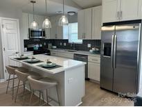 Bright kitchen with a center island, stainless steel appliances, and elegant pendant lighting at 1004 Johnson St, Charlotte, NC 28206