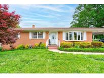 Charming brick home with well-manicured lawn, flowering bushes, and a welcoming front porch at 109 Ashley St, Shelby, NC 28150
