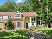 Charming exterior view of a two-story home with a brick accent, lush lawn and mature trees at 11121 Sevilla Ct, Charlotte, NC 28226