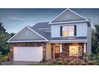 Charming two-story home featuring a stone facade, white siding, and an attached garage with landscaped yard at 136 Parker Claire Ln, Kings Mountain, NC 28086