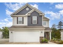 Charming two-story home with a two-car garage and stone accents, set against a beautiful blue sky at 18026 Stark Way, Charlotte, NC 28278