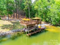 This waterfront property features a private covered dock with boat lift perfect for lakeside living and entertaining at 18311 Rosapenny Rd, Charlotte, NC 28278