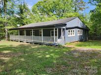 Charming single-story home with a spacious covered porch, nestled in a wooded lot offering privacy at 3225 Sawmill Rd, Hickory Grove, SC 29717