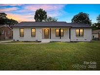 Charming brick home with a well-manicured lawn and inviting front porch exudes curb appeal at 3937 Tamerlane Dr, Charlotte, NC 28205