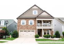 Inviting exterior with stone accents, covered porch, two car garage, and well-maintained lawn at 745 Garrett Green Way, Fort Mill, SC 29715